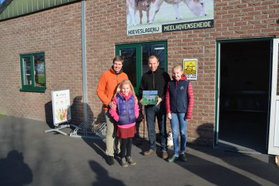 Jan, Leen en de kinderen voor hun winkel met de ontvangen klok met studieclublogo